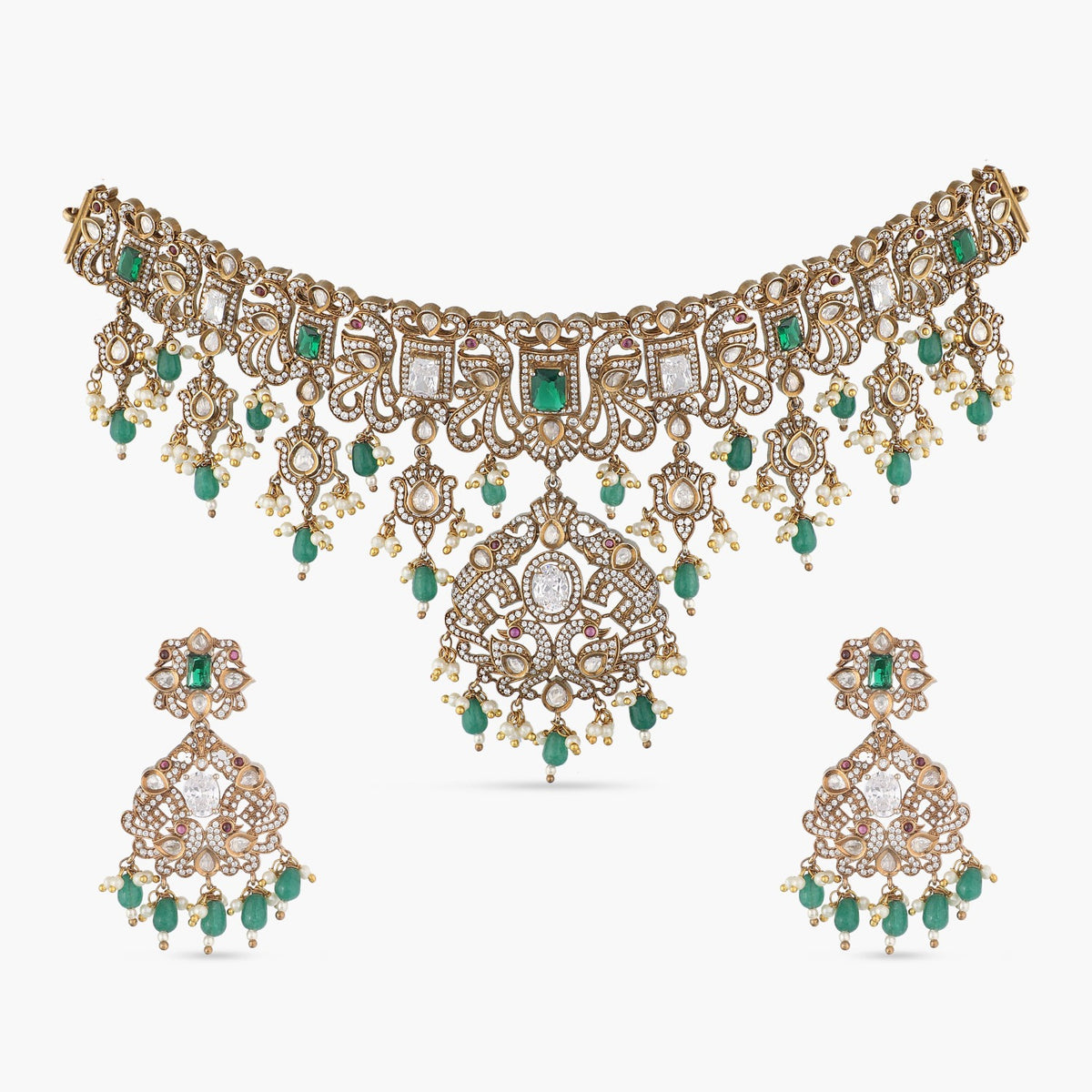 An image of Indian artificial jewelry. It is an antique gold plated short necklace with matching earrings set, featuring green gemstones and Cubic Zirconia.