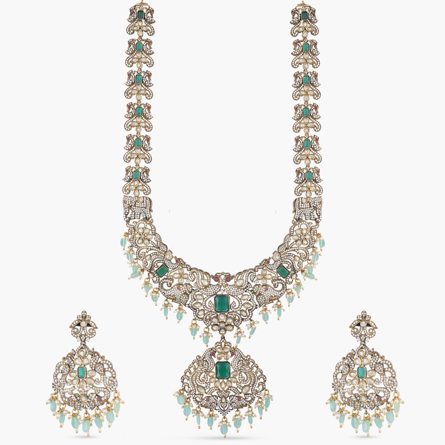 A picture of an Indian artificial jewelry set: a Victorian plated necklace and earrings with green gemstones and Cubic Zirconia.