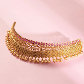 Gold-plated choker necklace on white surface