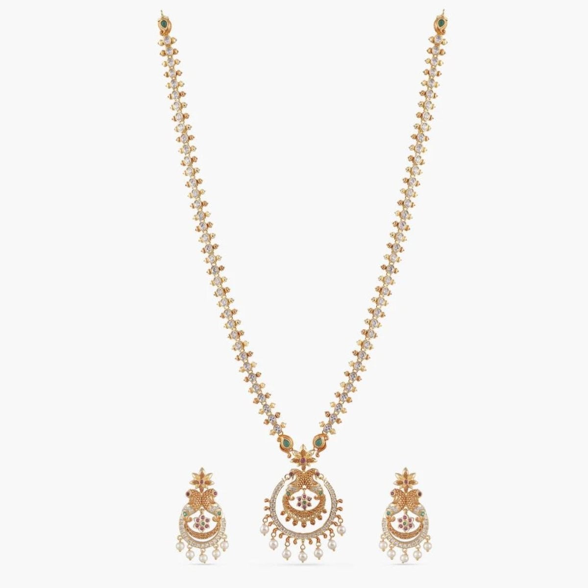 An image of Indian artificial jewelry. It is a gold necklace and earrings set with a peacock pendant, featuring Cubic Zirconia and green gemstones.