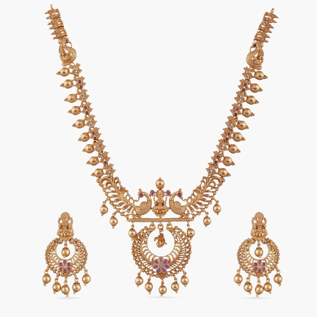 A picture of an Indian artificial jewelry set with a gold plated necklace and earrings featuring a peacock motifs in pendant.
