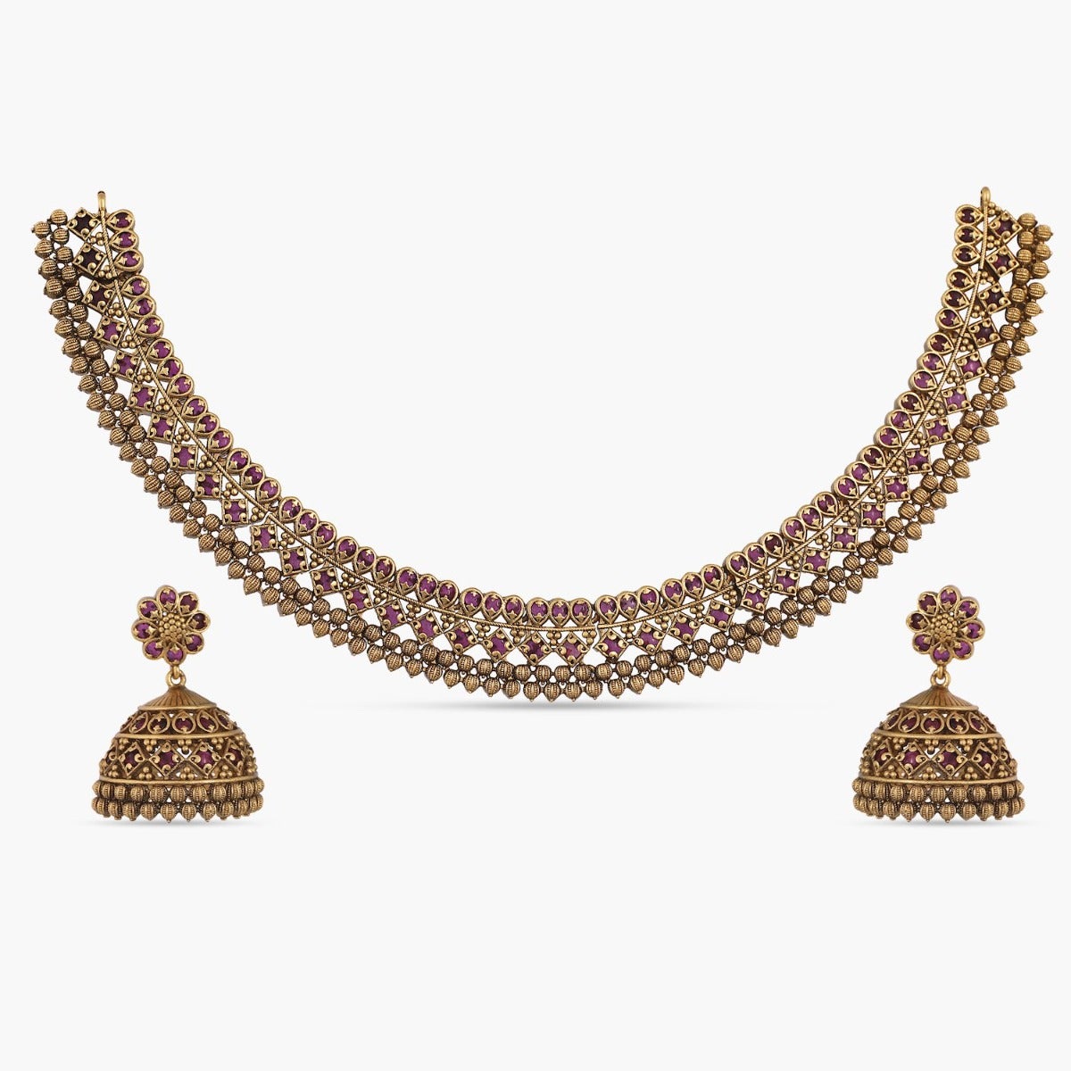 A picture of Indian artificial jewelry: an antique gold-colored necklace and earring set with red gemstones.