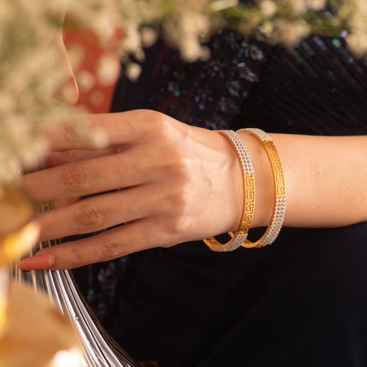  A picture of a pair of Indian artificial bangles, featuring a Greek key design with Cubic Zirconia.