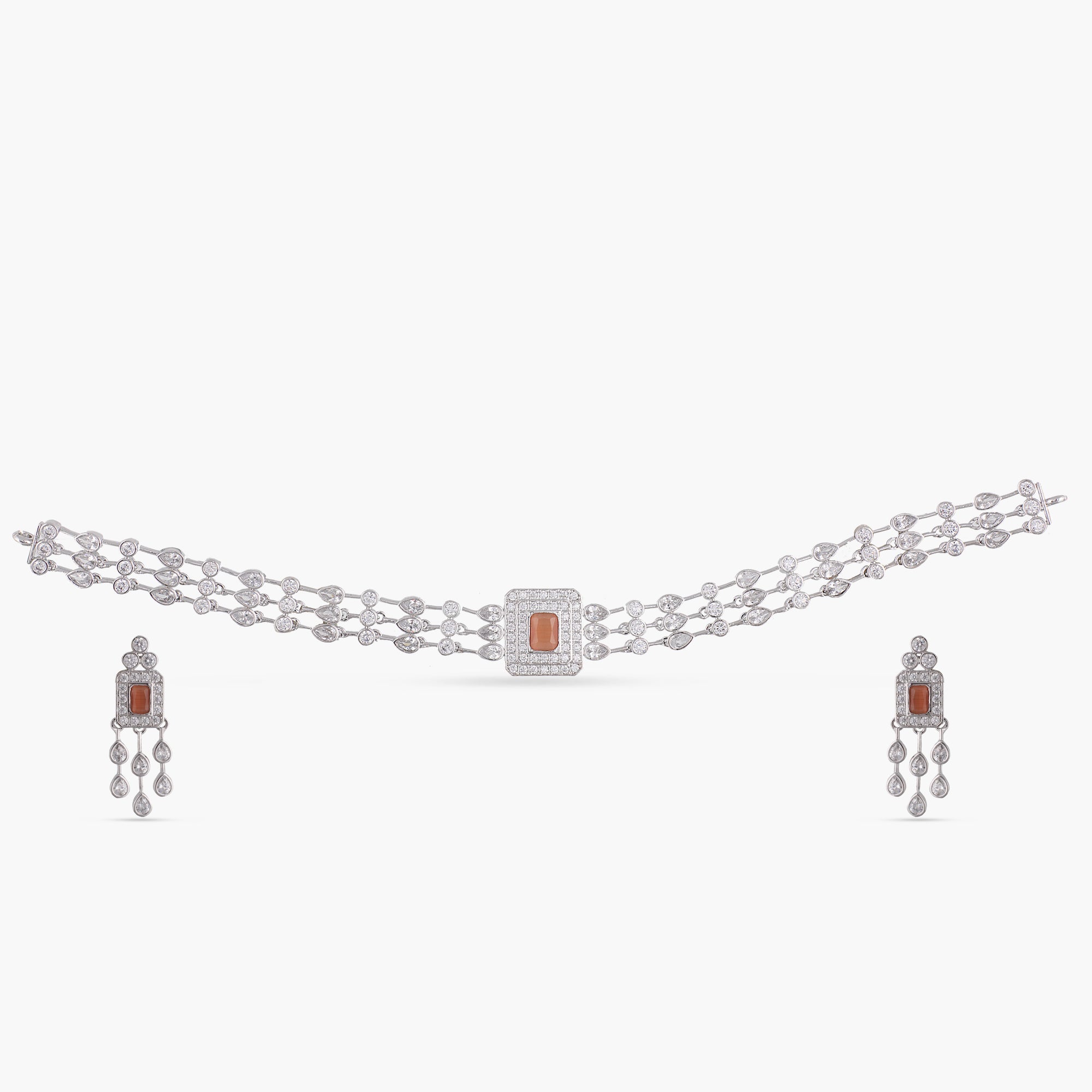 A picture of Indian artificial jewelry. It is a choker necklace and matching earrings set with Cubic Zirconia and red gemstones on a white background.