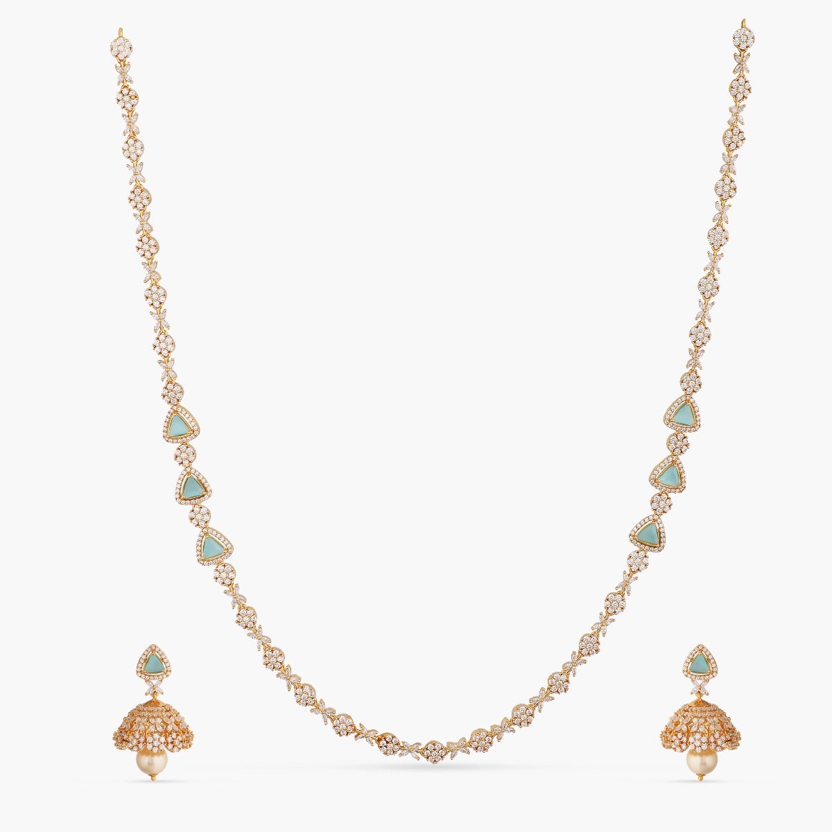 A picture of an Indian artificial jewelry set with a gold-toned necklace and matching earrings, featuring Cubic Zirconia and green stones.
