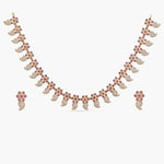 A picture of an Indian artificial jewelry set: a gold-plated necklace and earrings featuring teardrop-shaped red gemstones with Cubic Zirconia on a white background. 